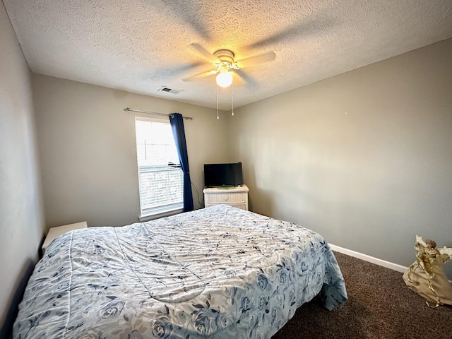 bedroom with a ceiling fan, baseboards, visible vents, carpet floors, and a textured ceiling