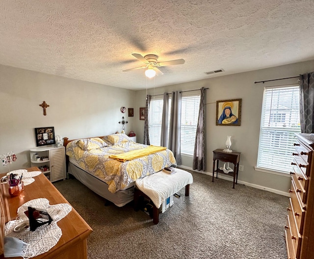 carpeted bedroom with visible vents, multiple windows, baseboards, and ceiling fan