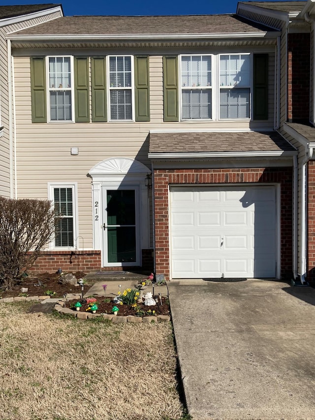 view of front of property with brick siding, roof with shingles, and driveway