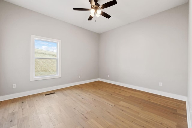 spare room with visible vents, baseboards, light wood-style floors, and a ceiling fan