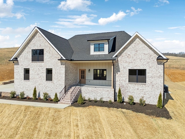 modern inspired farmhouse with a porch, brick siding, board and batten siding, and cooling unit