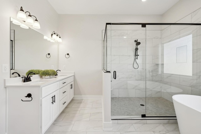 full bathroom featuring a sink, a freestanding tub, marble finish floor, and double vanity