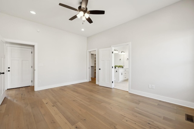 unfurnished bedroom with recessed lighting, baseboards, connected bathroom, and light wood-style floors