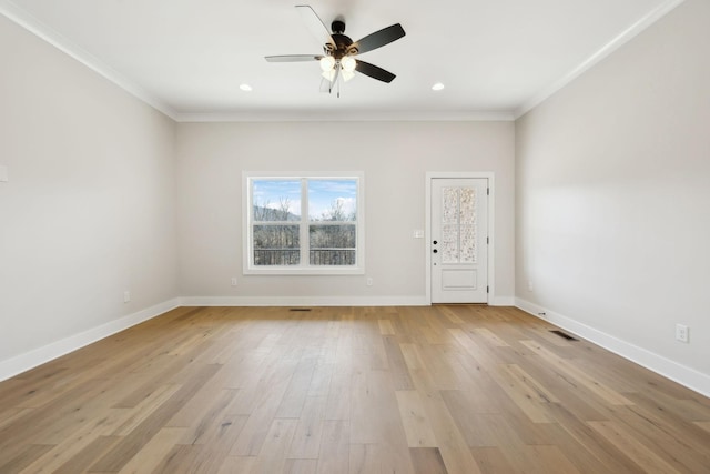 spare room with baseboards, light wood-style flooring, a ceiling fan, and ornamental molding