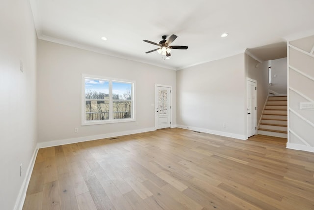 unfurnished living room featuring stairway, baseboards, ceiling fan, light wood-style floors, and crown molding