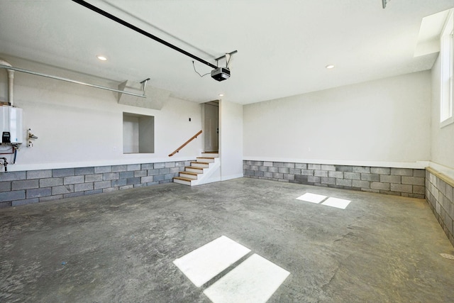 garage featuring tankless water heater and a garage door opener