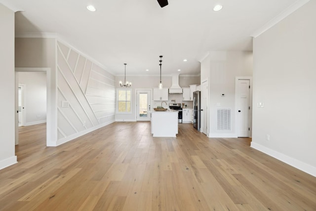 unfurnished living room featuring visible vents, ornamental molding, recessed lighting, light wood-style floors, and a notable chandelier