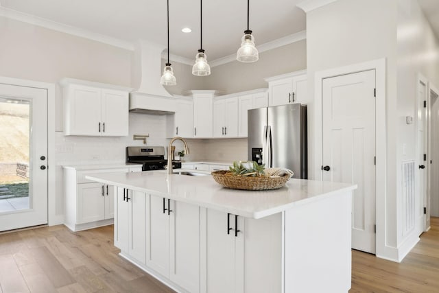 kitchen with light wood finished floors, stainless steel appliances, light countertops, and a sink