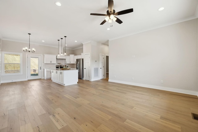 unfurnished living room with visible vents, baseboards, light wood-style flooring, crown molding, and ceiling fan with notable chandelier