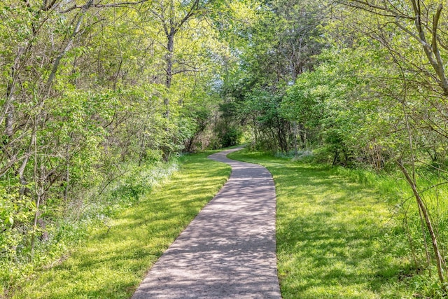 view of community featuring a lawn and a wooded view