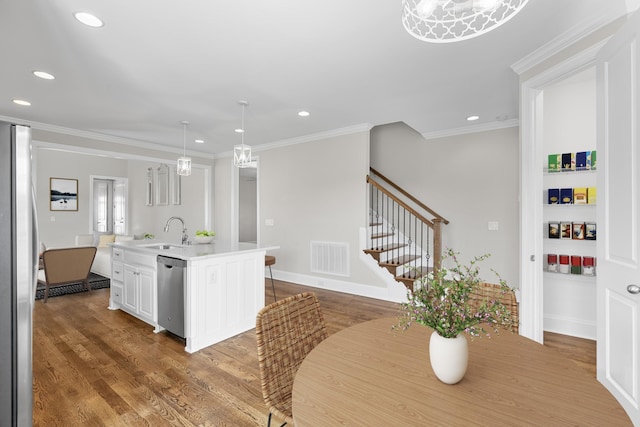 kitchen with a sink, stainless steel appliances, visible vents, and wood finished floors