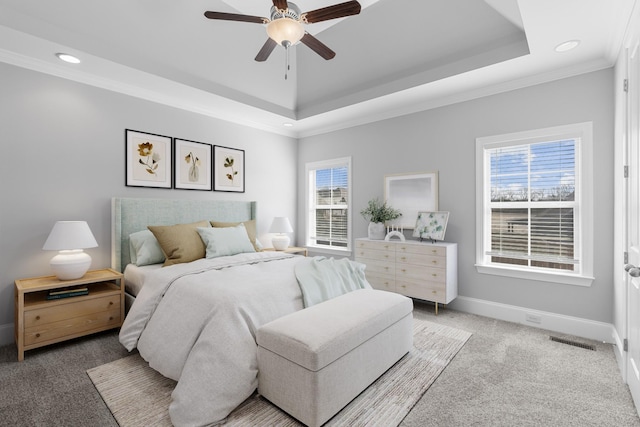 bedroom with visible vents, ornamental molding, a tray ceiling, baseboards, and light colored carpet