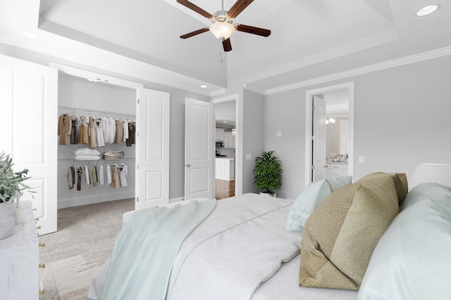 bedroom featuring recessed lighting, a tray ceiling, a spacious closet, and crown molding