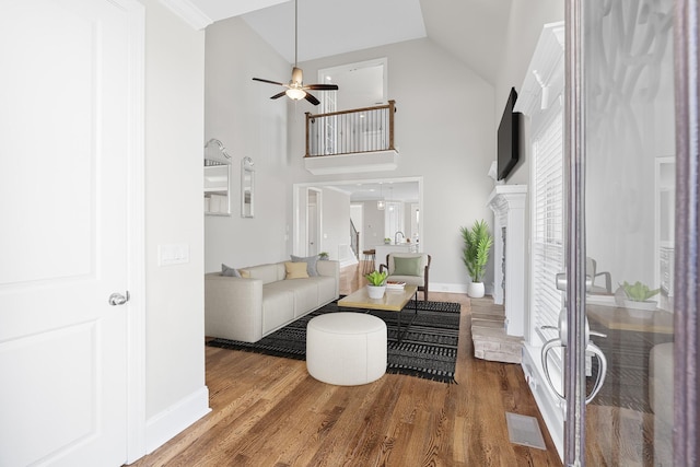 living room with high vaulted ceiling, wood finished floors, visible vents, and baseboards