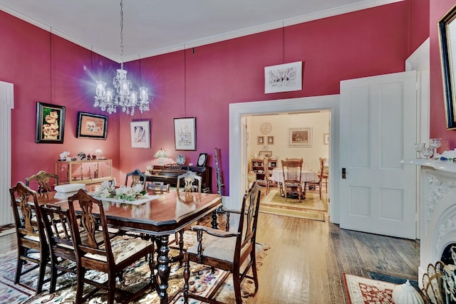 dining area with a chandelier, wood finished floors, and crown molding