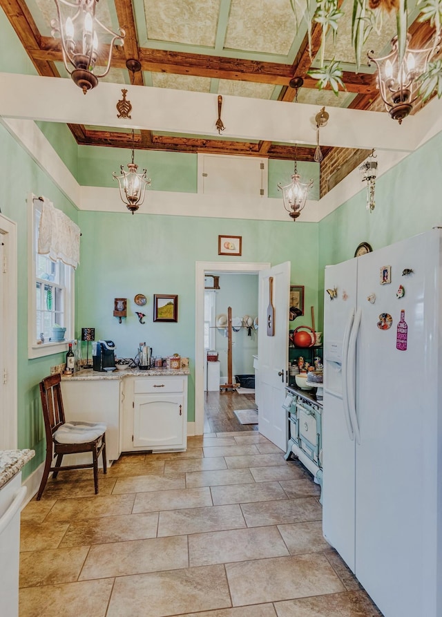 kitchen featuring white cabinetry, beamed ceiling, decorative light fixtures, and white fridge with ice dispenser