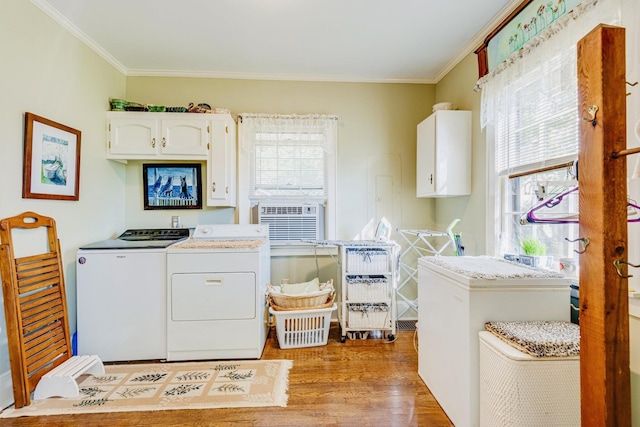 clothes washing area with crown molding, cooling unit, wood finished floors, cabinet space, and separate washer and dryer