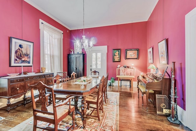 dining area featuring an inviting chandelier, wood finished floors, and ornamental molding