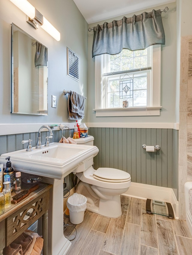 bathroom featuring visible vents, wainscoting, toilet, and wood finish floors