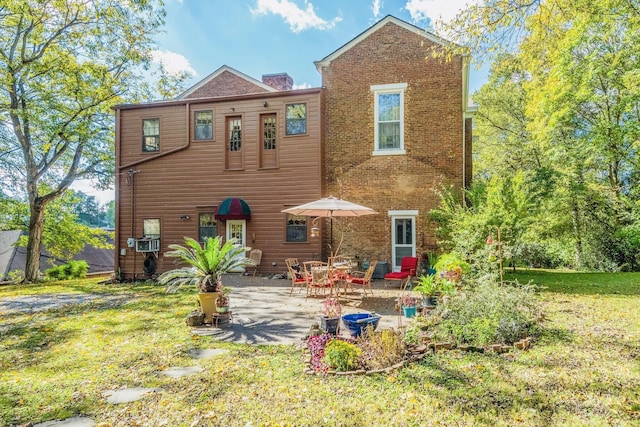 back of property with a patio, cooling unit, a lawn, and brick siding