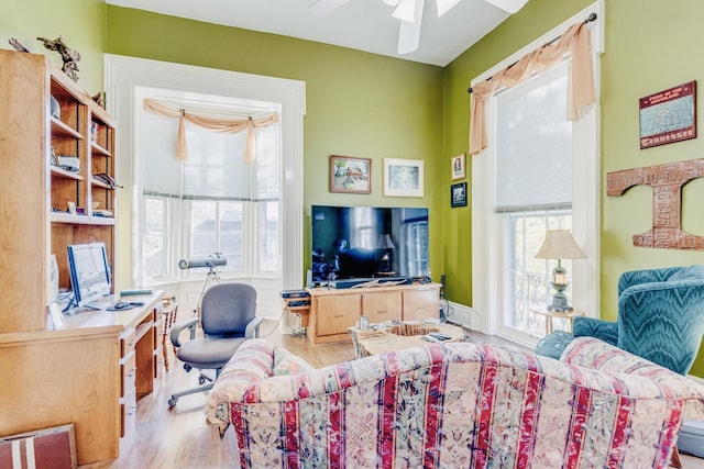 interior space featuring multiple windows, wood finished floors, and ceiling fan