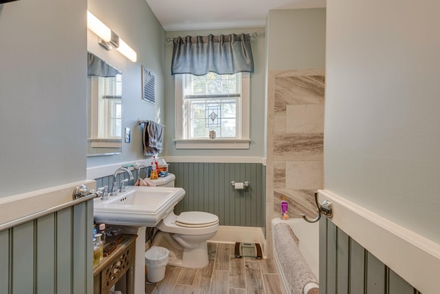 full bath with a wainscoted wall, a sink, toilet, and wood finished floors