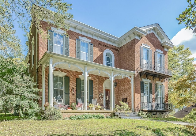 italianate-style house with brick siding, covered porch, and a front lawn