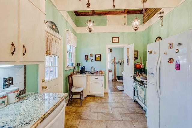 kitchen with decorative light fixtures, white refrigerator with ice dispenser, light stone countertops, and tasteful backsplash