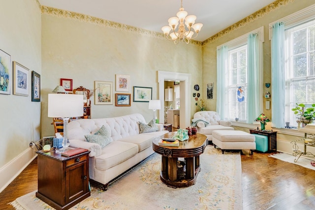 living area with an inviting chandelier, wood finished floors, and baseboards