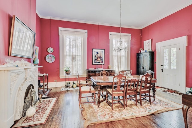 dining area with a notable chandelier, wood finished floors, and ornamental molding