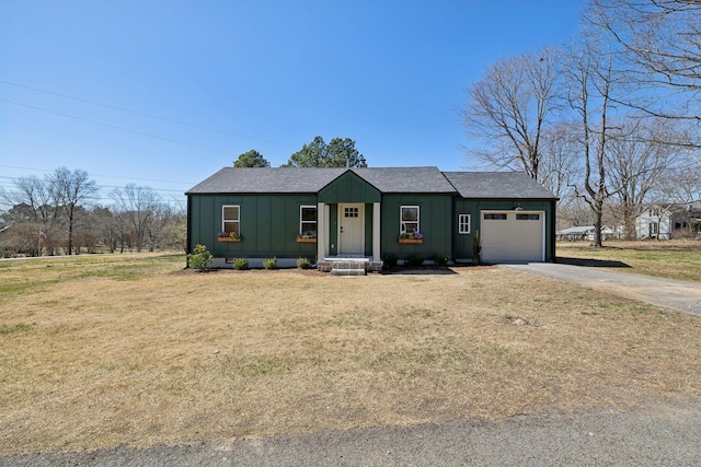 view of front of property with a front lawn, driveway, board and batten siding, an attached garage, and crawl space