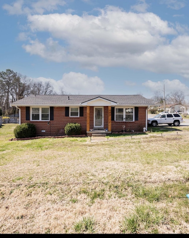 ranch-style house with crawl space, brick siding, a front yard, and a shingled roof