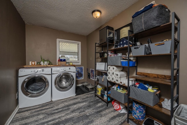 laundry area with baseboards, washer and clothes dryer, laundry area, wood finished floors, and a textured ceiling