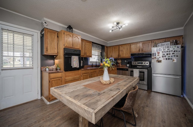 kitchen featuring ornamental molding, stainless steel appliances, dark wood-type flooring, a textured ceiling, and exhaust hood