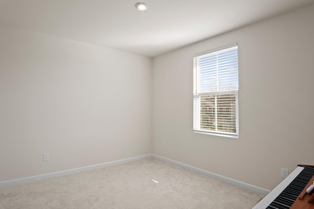 carpeted spare room featuring baseboards