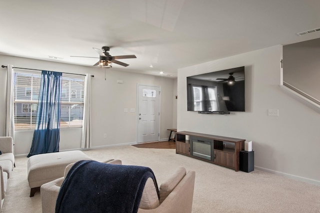 carpeted living area featuring visible vents, baseboards, and a ceiling fan