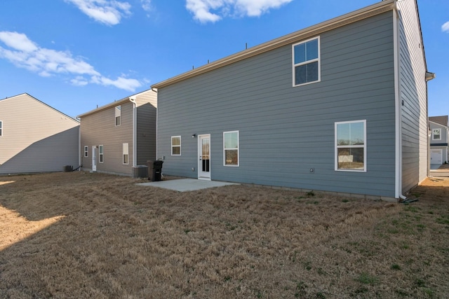 rear view of property with a yard, central air condition unit, and a patio