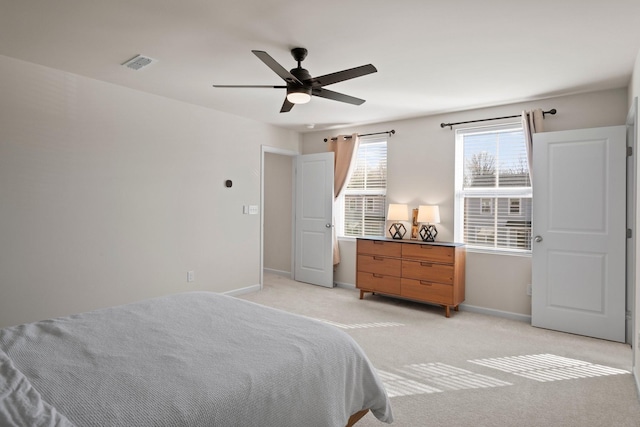 bedroom with a ceiling fan, baseboards, visible vents, and light carpet