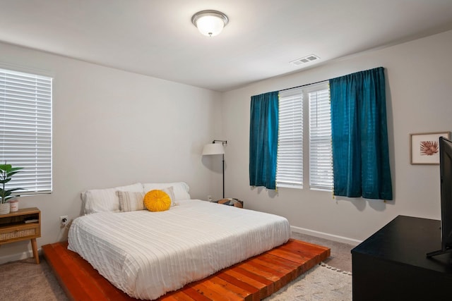 carpeted bedroom with visible vents and baseboards