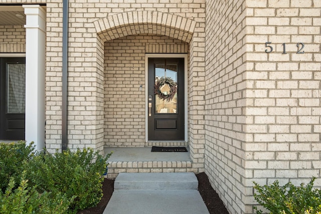 doorway to property with brick siding