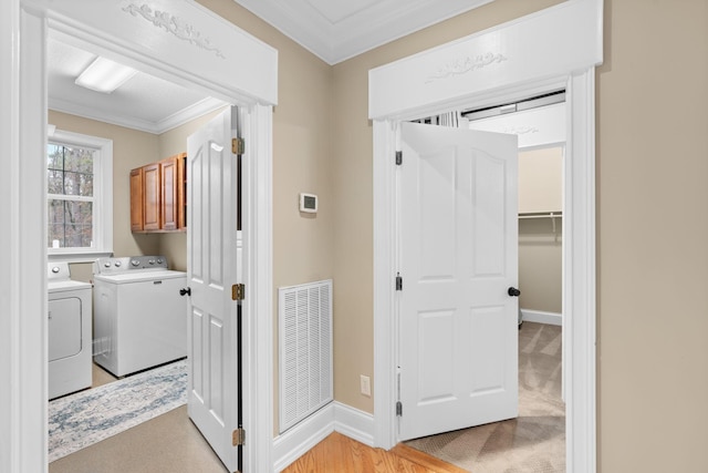 corridor featuring crown molding, baseboards, visible vents, and washer and clothes dryer