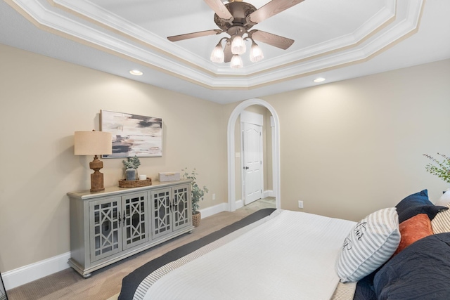 bedroom featuring arched walkways, baseboards, carpet, and a tray ceiling