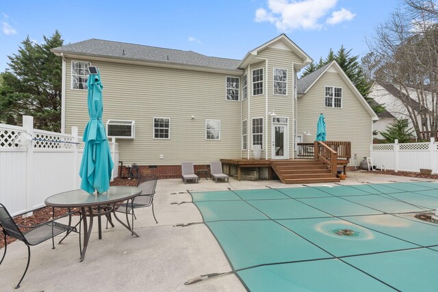 back of property with a deck, a patio, a fenced backyard, and a fenced in pool