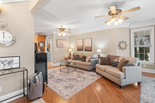 living room with light wood-style flooring, a ceiling fan, and crown molding