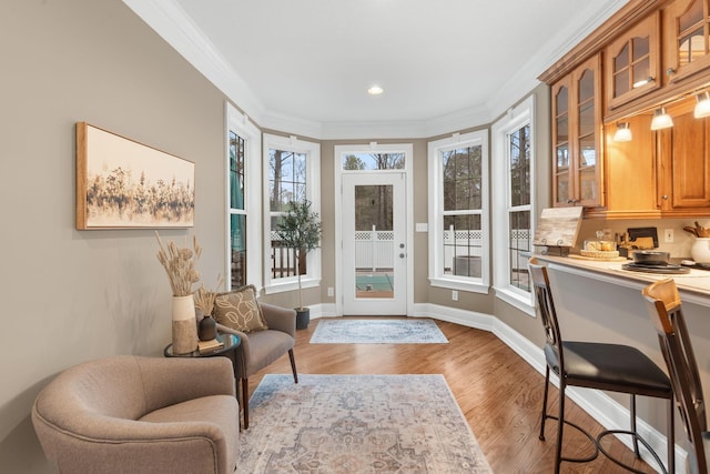 interior space featuring recessed lighting, wood finished floors, baseboards, and ornamental molding