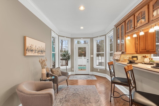 interior space with recessed lighting, wood finished floors, baseboards, and ornamental molding