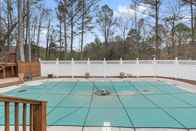 view of swimming pool featuring a fenced in pool, a deck, and fence