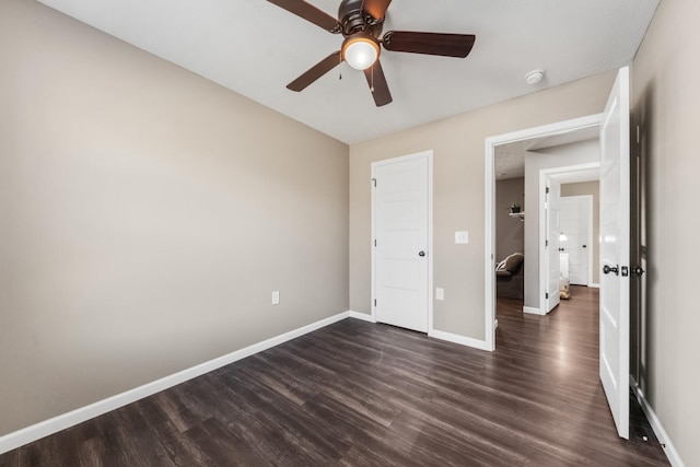 unfurnished bedroom with ceiling fan, baseboards, and dark wood-style flooring