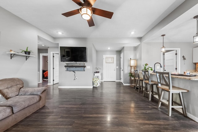 living area with dark wood-type flooring, recessed lighting, a ceiling fan, and baseboards