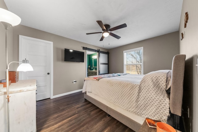 bedroom featuring dark wood finished floors, a barn door, a ceiling fan, and baseboards